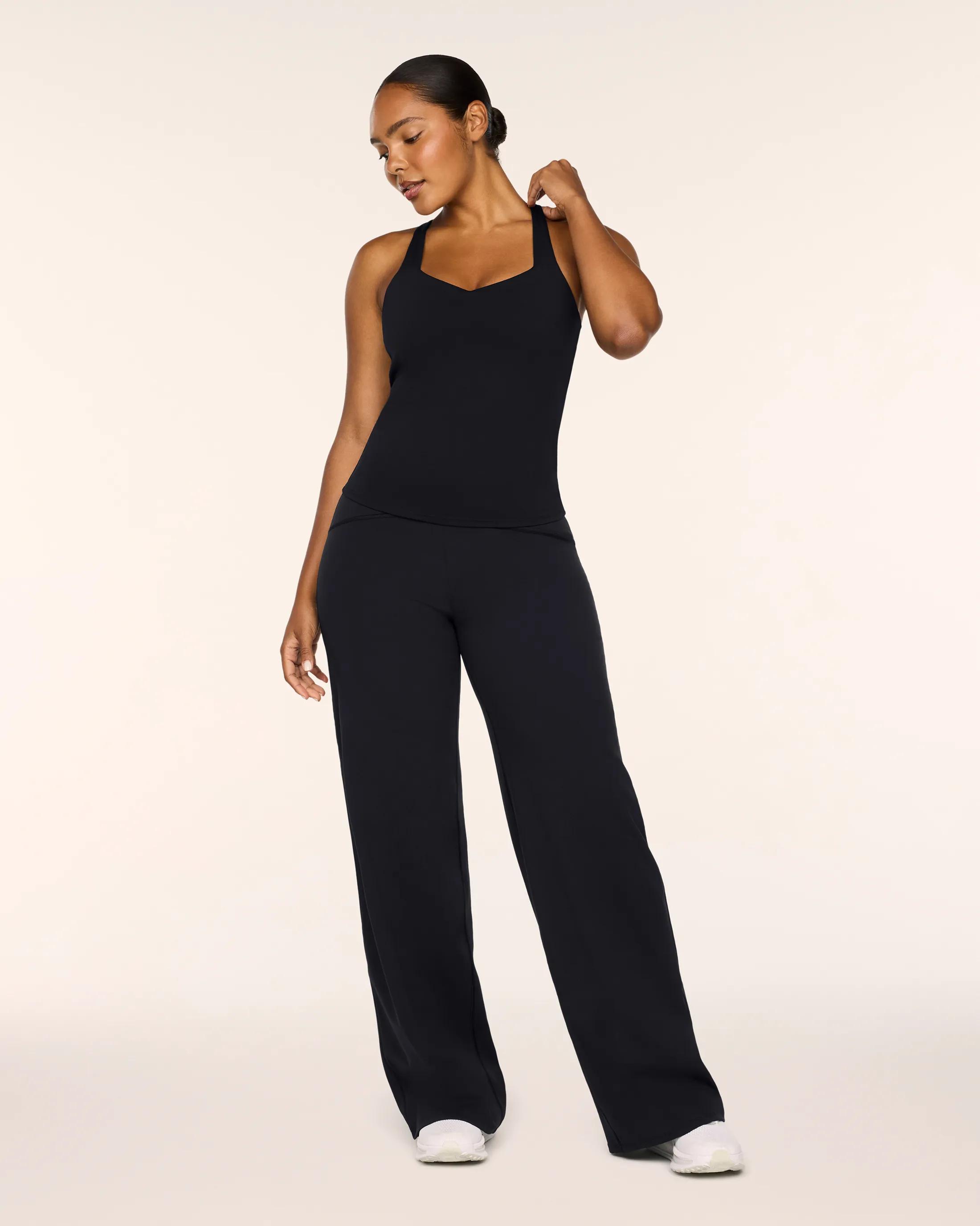 Model standing in Spanx Boost up tank and booty boost wide leg pant