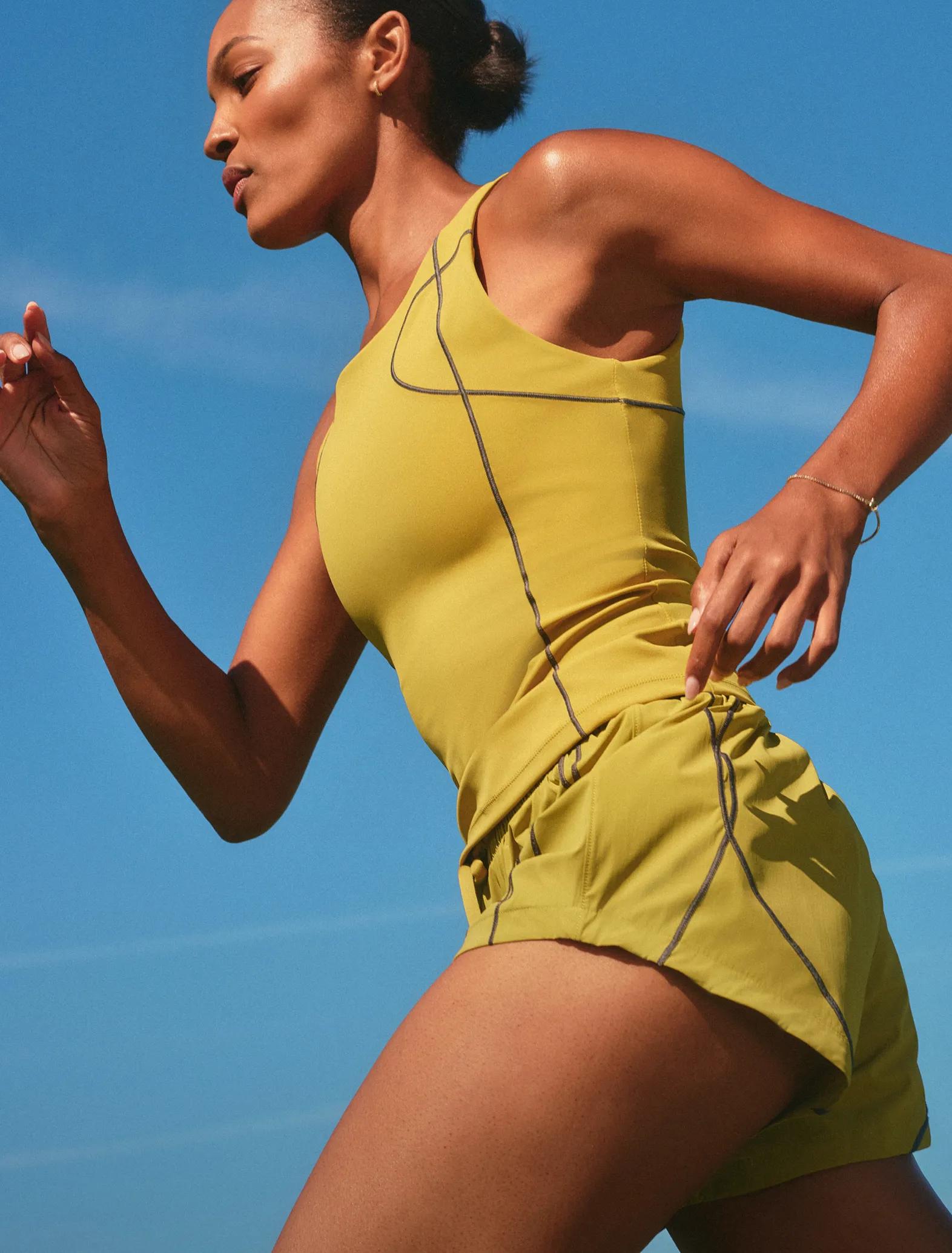model in Spanx run club tank and shorts in pear color