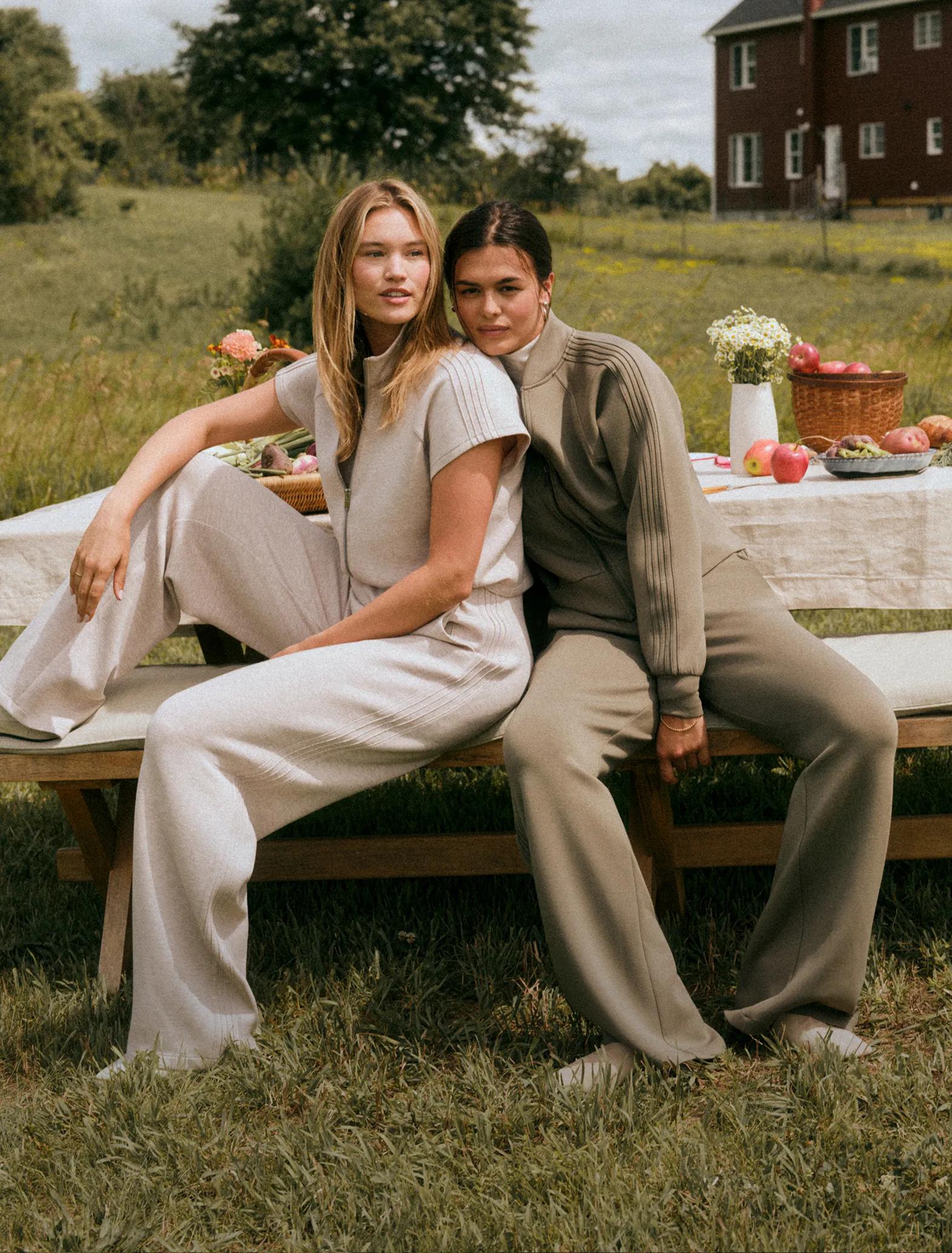 two women in spanx airessentials pintuck matching sets on a picnic bench