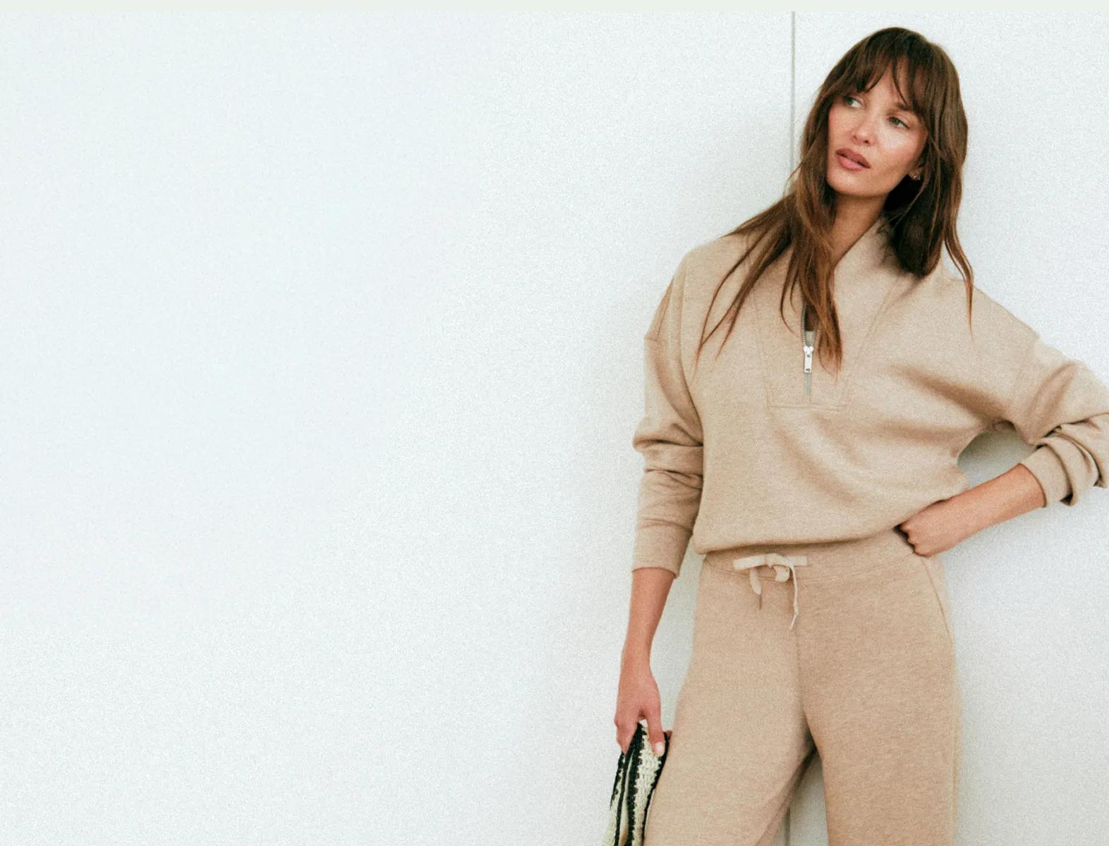 Model wearing an oatmeal heathered quarter-zip pullover and matching jogger pants