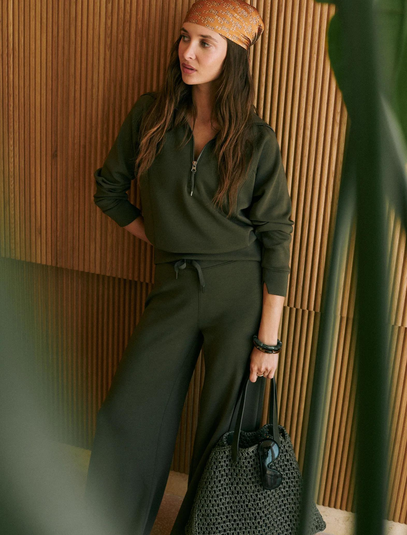 Woman in monstera green airessentials half zip and wide leg pant