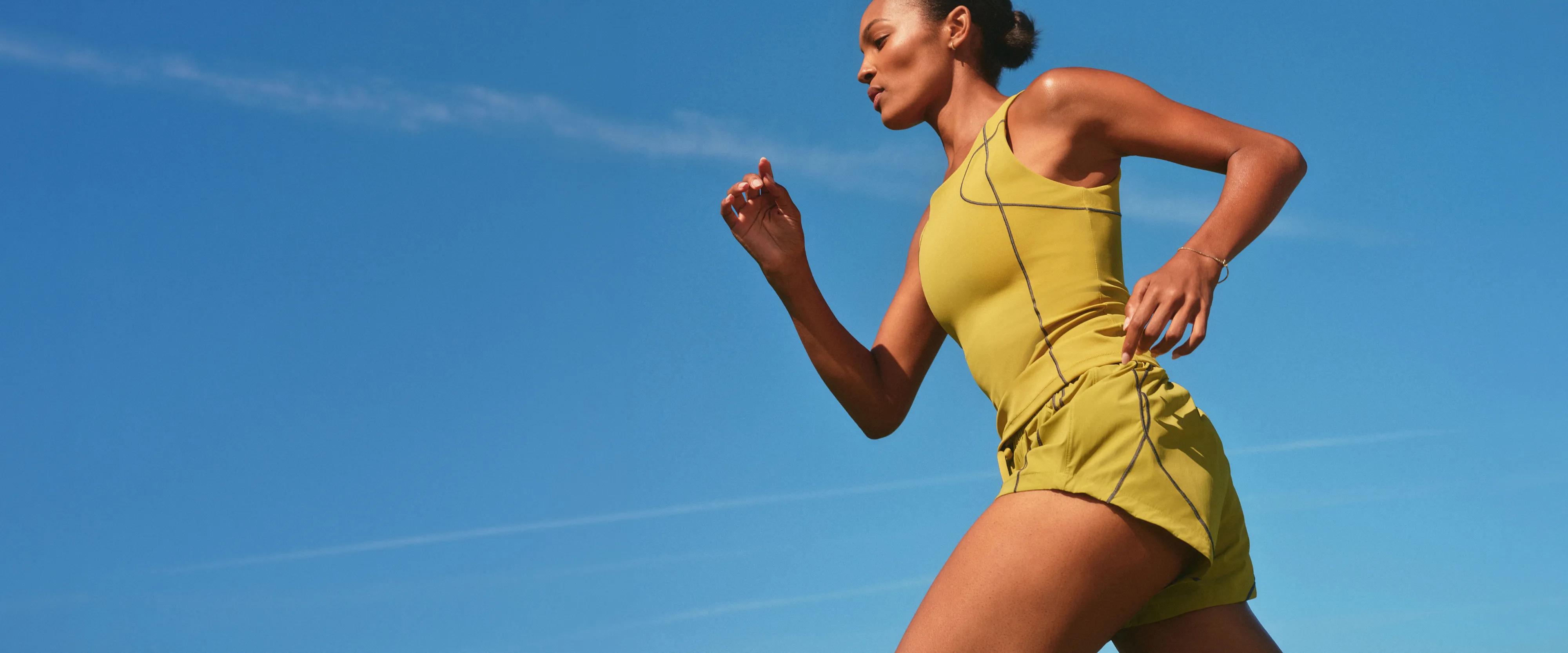 model in Spanx run club tank and shorts in pear color