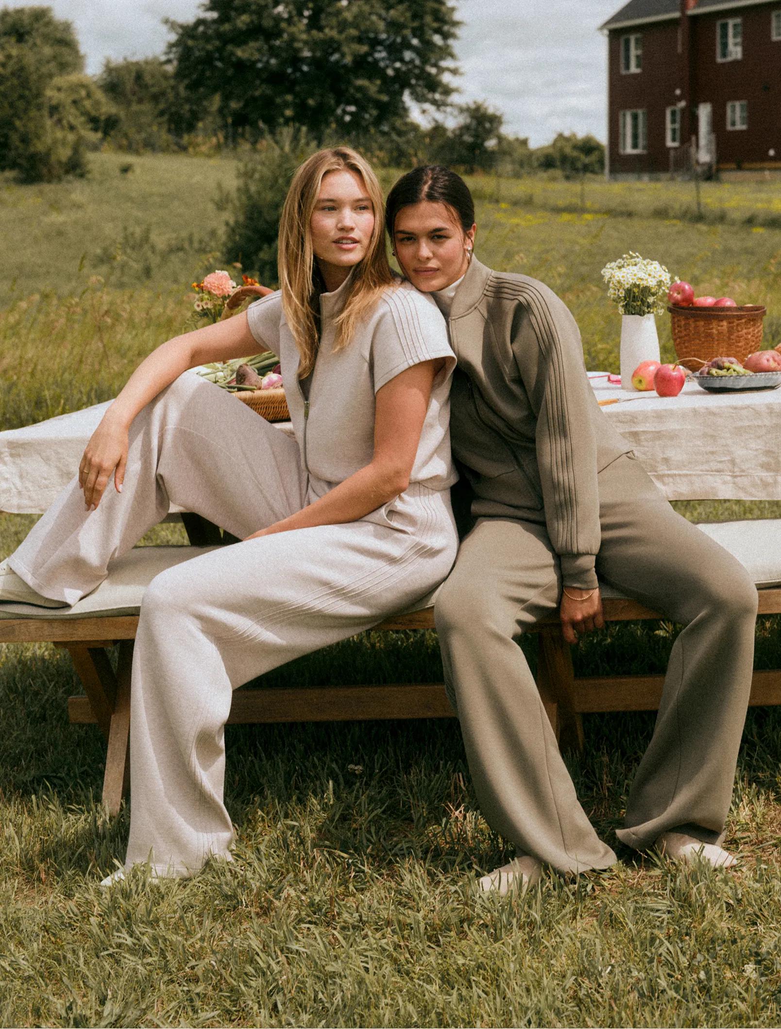 two women sitting on a bench in Spanx Airessentials Pintuck sets